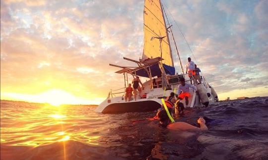 Réduction au lever du soleil sur un catamaran à voile privé