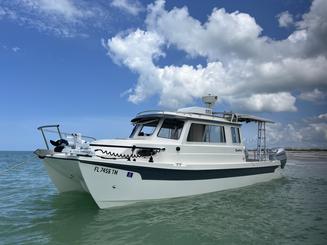 Catamaran à cabine de 26 pieds piloté par Scott Guttery, originaire de la SWFL