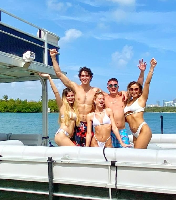 A group of friends, posing on a pontoon boat in Miami.