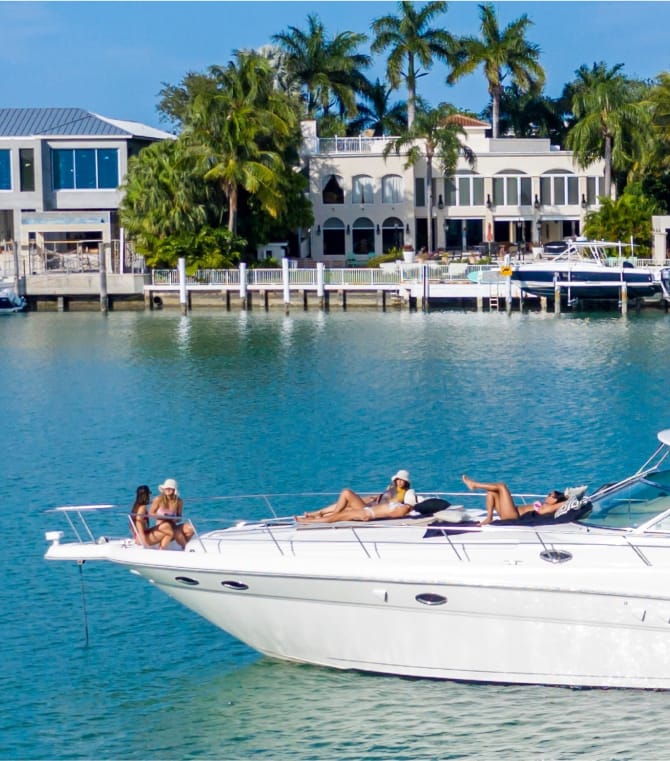 Several people relaxing and enjoying the day, from the bow of a yacht.